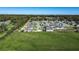 An aerial shot showcases a community home with a green lawn, surrounded by lush trees and fields at 3467 Sutton Ridge St, Lakeland, FL 33810
