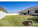 Spacious backyard with green grass, fenced perimeter, and outdoor seating around a grill at 3467 Sutton Ridge St, Lakeland, FL 33810