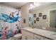Charming bathroom with a granite countertop, white cabinets, and colorful shower curtain at 3467 Sutton Ridge St, Lakeland, FL 33810