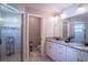 Modern bathroom with dual vanities, granite countertops, and glass-enclosed shower, offering a spa-like feel at 3467 Sutton Ridge St, Lakeland, FL 33810