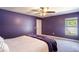Cozy bedroom features purple walls, carpet, and a large bed with a decorative ceiling fan at 3467 Sutton Ridge St, Lakeland, FL 33810