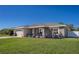 Inviting single-story home boasts a well-manicured lawn, neutral exterior, and charming front porch at 3467 Sutton Ridge St, Lakeland, FL 33810