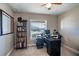 Functional home office with a large desk, organized bookshelf, and natural light from the window at 3467 Sutton Ridge St, Lakeland, FL 33810