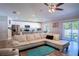 Spacious living room with a white sectional sofa, hardwood floors, and access to outdoor patio at 3467 Sutton Ridge St, Lakeland, FL 33810
