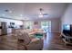Open-concept living room with hardwood floors and ample natural light, adjacent to the kitchen at 3467 Sutton Ridge St, Lakeland, FL 33810