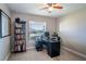 Well-lit office space with ceiling fan, large window, and dark-colored desk and shelving at 3467 Sutton Ridge St, Lakeland, FL 33810