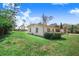 View of the rear of the home with a spacious backyard and lush greenery at 352 W Graham Park Dr, Haines City, FL 33844