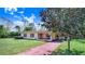 Front view of the home with a mature tree in the yard and extended driveway at 352 W Graham Park Dr, Haines City, FL 33844