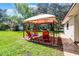 Backyard featuring a gazebo with patio furniture and a grill, providing an outdoor space for relaxing and dining at 3614 Twisted Oak Ct, Lake Wales, FL 33898