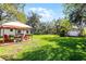 Lush backyard features a green lawn, mature trees, and an outdoor dining area perfect for entertaining at 3614 Twisted Oak Ct, Lake Wales, FL 33898