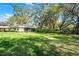 Large grassy backyard showcases ample open space and mature trees providing shade at 3614 Twisted Oak Ct, Lake Wales, FL 33898