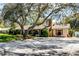 Charming single-story home with brick chimney, well-maintained landscaping, and large shade tree in the front yard at 3614 Twisted Oak Ct, Lake Wales, FL 33898