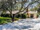 Single-story home with brick chimney, complemented by mature shrubs, and a beautiful shade tree at 3614 Twisted Oak Ct, Lake Wales, FL 33898