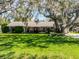 Charming one-story home featuring a lush green lawn and mature trees draped with Spanish moss at 3614 Twisted Oak Ct, Lake Wales, FL 33898