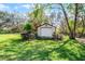 View of the stand alone one-car garage surrounded by lush greenery at 3614 Twisted Oak Ct, Lake Wales, FL 33898