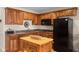 Well-equipped kitchen with wooden cabinets, black appliances, and a butcher block island at 3614 Twisted Oak Ct, Lake Wales, FL 33898