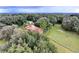 Scenic aerial shot of a tile roofed house surrounded by lush trees, with a shed at 3655 N Scenic Hwy, Lake Wales, FL 33898