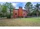 Backyard view of a two-story brick house with mature trees and chain link fencing at 3655 N Scenic Hwy, Lake Wales, FL 33898