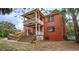 Backyard view of a two-story brick house with a stairway, porch, and lush greenery at 3655 N Scenic Hwy, Lake Wales, FL 33898