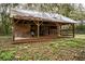 Rustic barn featuring aged wood, metal roof, and open stalls, surrounded by foliage at 3655 N Scenic Hwy, Lake Wales, FL 33898