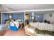 An unfinished basement features textured tile flooring, blue painted walls, and assorted personal items and furniture at 3655 N Scenic Hwy, Lake Wales, FL 33898