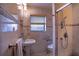 This well-lit bathroom features tiled walls, a toilet, a glass enclosed shower and a pedestal sink with chrome fixtures at 3655 N Scenic Hwy, Lake Wales, FL 33898