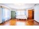 Bright bedroom featuring hardwood floors, a daybed, and an armoire, with natural light from the large window at 3655 N Scenic Hwy, Lake Wales, FL 33898