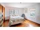 Bedroom with wood floors, striped bedding, large window, and light blue chair at 3655 N Scenic Hwy, Lake Wales, FL 33898