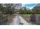 View of a long driveway leading up to a large home with mature trees in a rural setting at 3655 N Scenic Hwy, Lake Wales, FL 33898