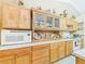 Well-lit kitchen featuring upper glass-front cabinets, a microwave, and decorative backsplash at 3690 Wellington Pl, Bartow, FL 33830