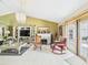 Cozy living room with a fireplace, chandelier, and access to the patio at 3690 Wellington Pl, Bartow, FL 33830