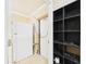 Storage area with a refrigerator, door, and shelving unit for efficient organization at 3690 Wellington Pl, Bartow, FL 33830