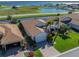 Beautiful home featuring a brick driveway, tropical landscaping, and water views at 4115 Muirfield Loop, Lake Wales, FL 33859