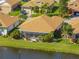 Aerial view of a home with a screened patio, lush landscaping, and a tranquil waterfront setting at 4115 Muirfield Loop, Lake Wales, FL 33859