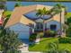 Aerial view of a charming home with a brick driveway, mature landscaping, and canal waterfront at 4115 Muirfield Loop, Lake Wales, FL 33859