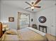 Bedroom with hardwood floors, neutral colored walls, ceiling fan, window, and small table at 4115 Muirfield Loop, Lake Wales, FL 33859