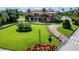 Beautiful clubhouse featuring manicured lawns, mature trees, and a circular driveway at 4115 Muirfield Loop, Lake Wales, FL 33859