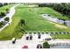 Aerial view of a lush green driving range with multiple hitting bays and golf carts at 4115 Muirfield Loop, Lake Wales, FL 33859