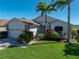 Charming home featuring a brick driveway, well-manicured lawn, and lush landscaping with tropical palm trees at 4115 Muirfield Loop, Lake Wales, FL 33859