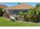 Backyard view featuring a lovely screened-in patio surrounded by lush landscaping and mature trees at 4115 Muirfield Loop, Lake Wales, FL 33859