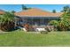 Beautiful home exterior with a screened lanai, mature palms, and well-maintained landscaping at 4115 Muirfield Loop, Lake Wales, FL 33859