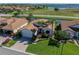Lovely single-story home showcasing mature landscaping, brick driveway, and an attached two-car garage at 4115 Muirfield Loop, Lake Wales, FL 33859