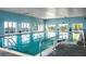Bright indoor pool area with clear water, stainless steel ladders, and a serene, inviting ambiance at 4115 Muirfield Loop, Lake Wales, FL 33859