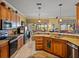Bright kitchen with granite countertops, wood cabinetry, stainless steel appliances, and an open layout to the dining and living areas at 4115 Muirfield Loop, Lake Wales, FL 33859