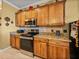 Well-equipped kitchen featuring wood cabinets, granite countertops, and stainless steel appliances at 4115 Muirfield Loop, Lake Wales, FL 33859