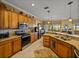 Updated kitchen featuring granite countertops, wood cabinets, stainless steel appliances, and an open design to the dining area at 4115 Muirfield Loop, Lake Wales, FL 33859