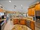 Spacious kitchen with granite counters, stainless appliances, wood cabinets, and an open view to the dining and living areas at 4115 Muirfield Loop, Lake Wales, FL 33859