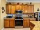 Kitchen featuring wood cabinetry, granite countertops, and stainless steel appliances at 4115 Muirfield Loop, Lake Wales, FL 33859