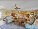 Bright living room featuring hardwood floors, open concept with kitchen and dining, and comfortable seating at 4115 Muirfield Loop, Lake Wales, FL 33859