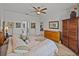 Main bedroom with wood floors, a ceiling fan, king size bed and en suite bathroom at 4115 Muirfield Loop, Lake Wales, FL 33859
